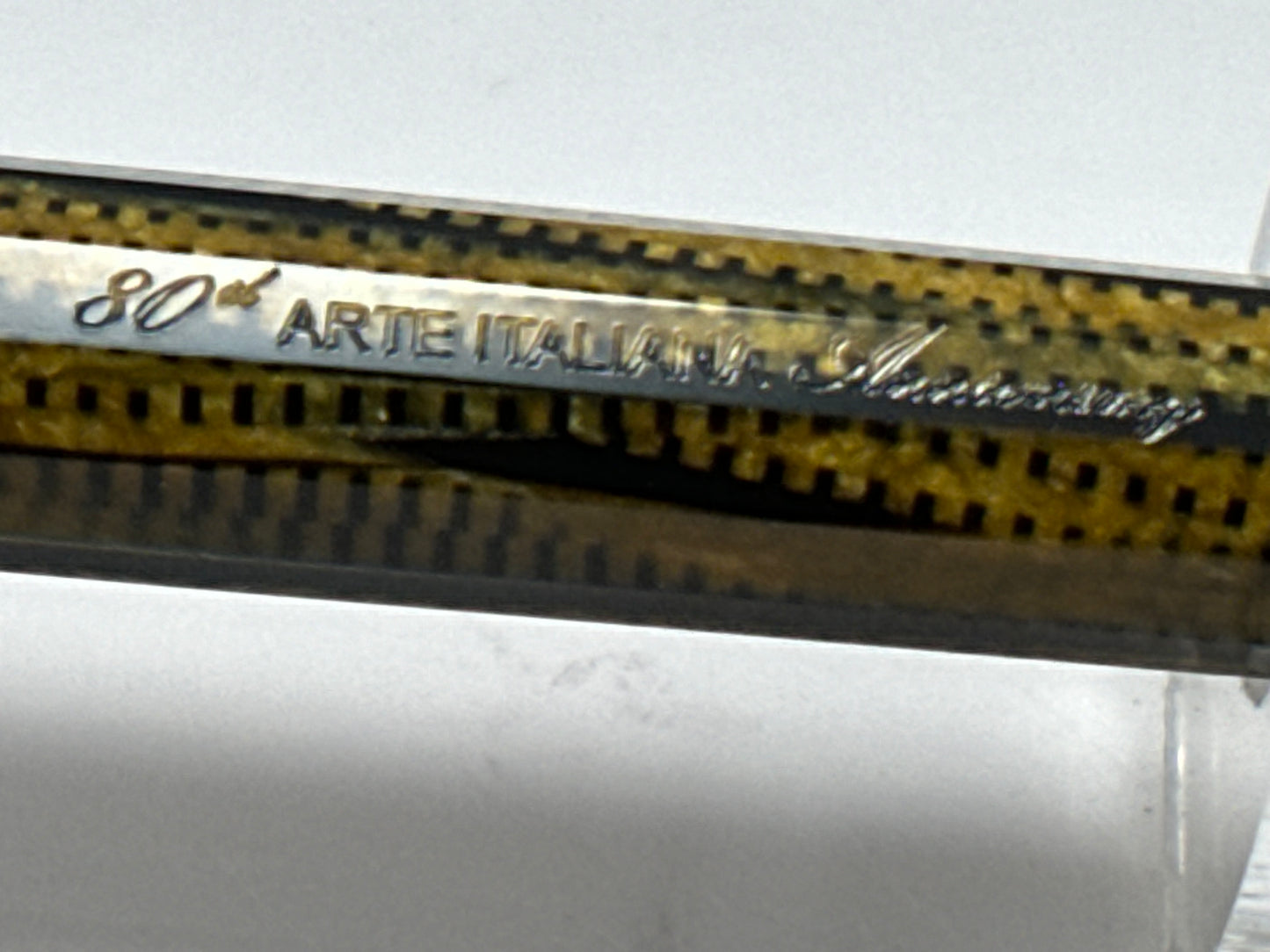 Close-up of a blade with '80 Arte Italiana' branding on a white background